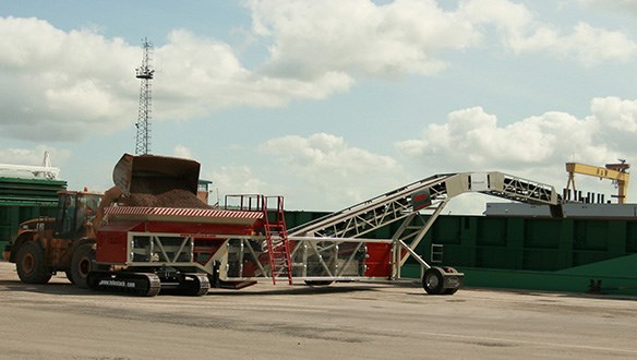 Mobile hopper feeder loading coaster vessels from wheel loader
